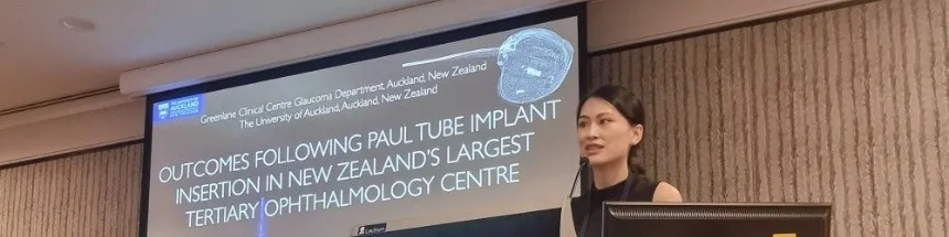 Dr Mia Zhang speaking at a conference with an ophthalmology presentation on screen.